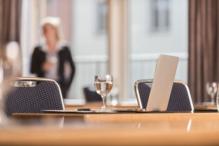  Detailansicht eines Konferenzraums im Maritim proArte Hotel Berlin mit Fokus auf Laptop und Wasserglas.