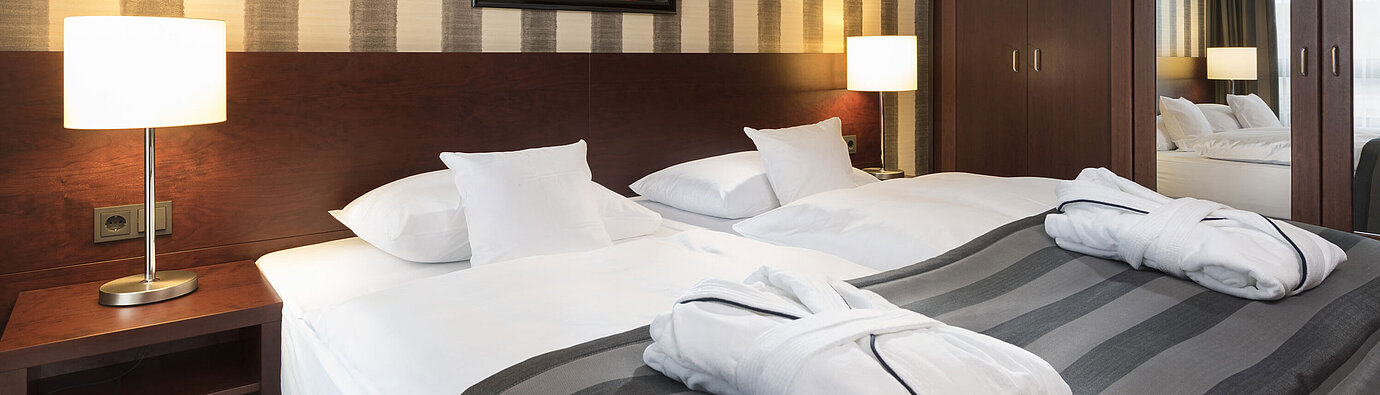 Modernes Doppelzimmer mit gemütlichem Bett, Bademänteln und stilvollem Interieur im Maritim Hotel Königswinter.