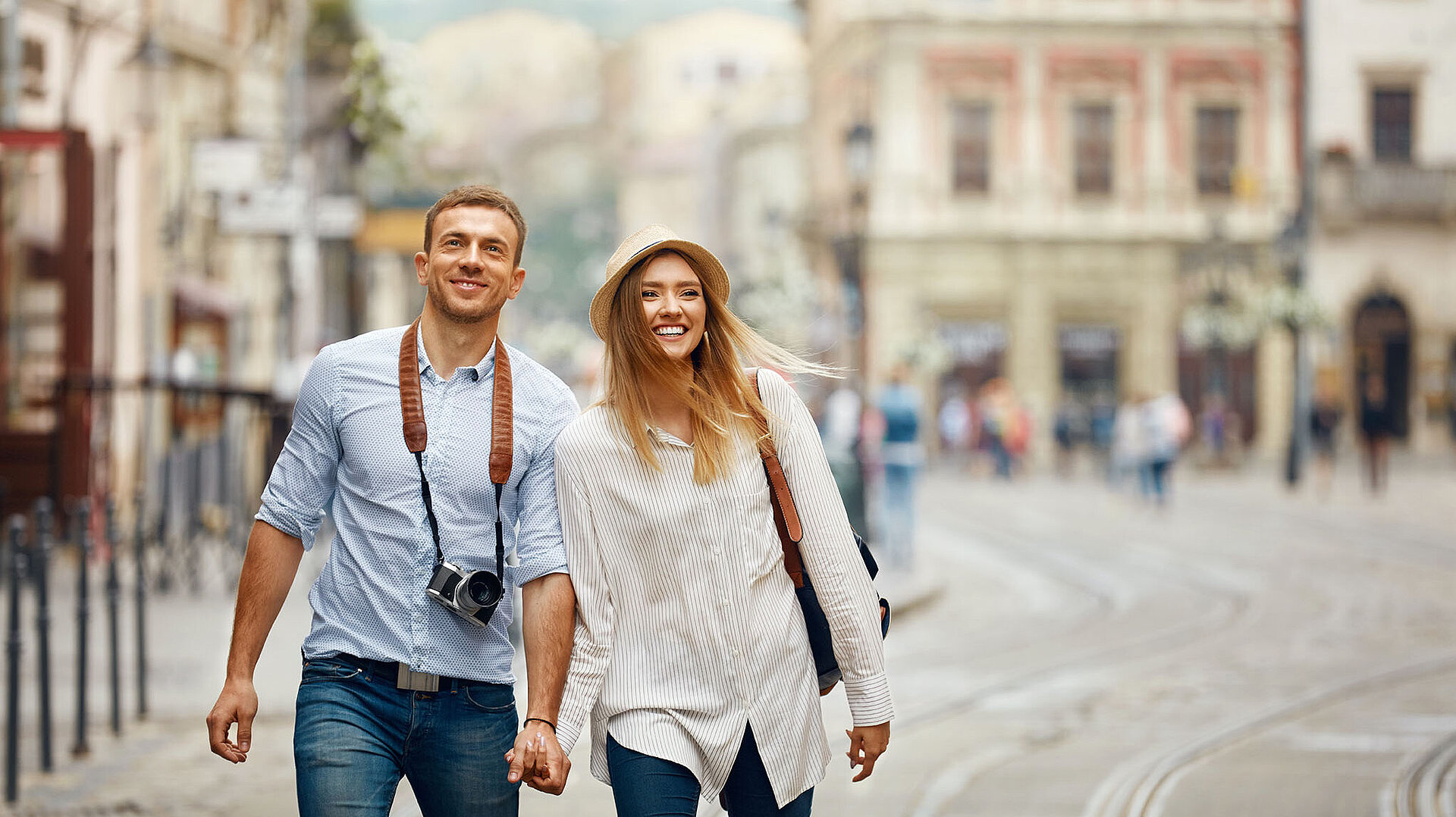 Glückliches Paar spaziert Hand in Hand durch eine historische Altstadt