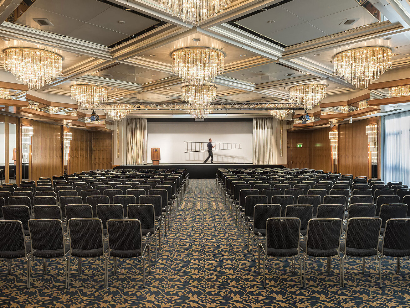 Eleganter Veranstaltungssaal mit Kristalllüstern, Reihenbestuhlung und großer Bühne im Maritim Hotel Hannover.