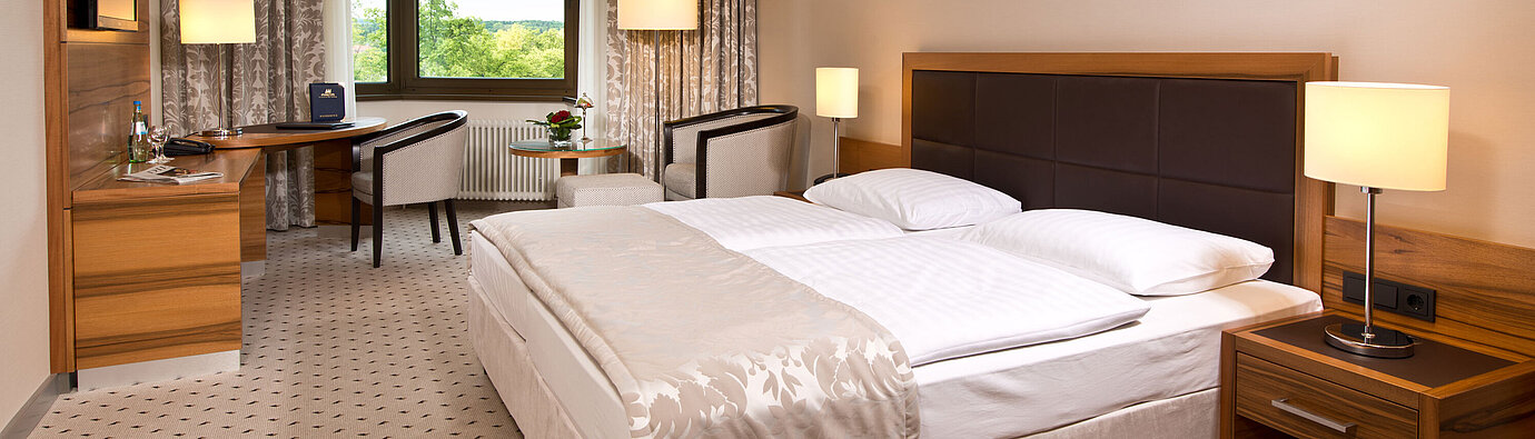 Komfortables Hotelzimmer im Maritim Hotel Bad Homburg mit modernem Design und Blick ins Grüne.