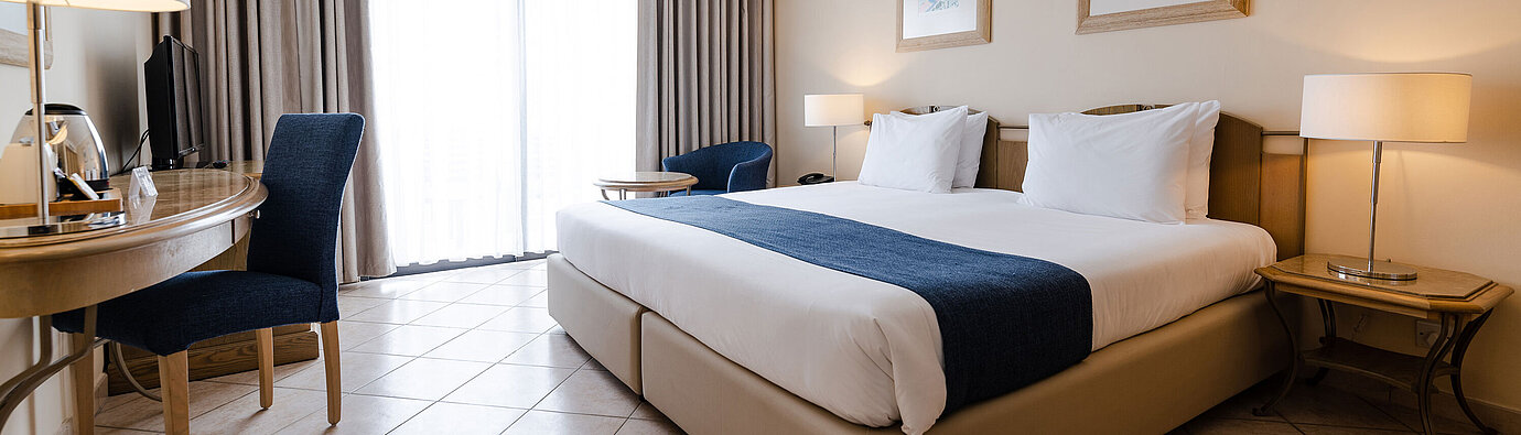 Helles Doppelzimmer mit Balkon, Schreibtisch, Sitzecke und bodentiefem Fenster
