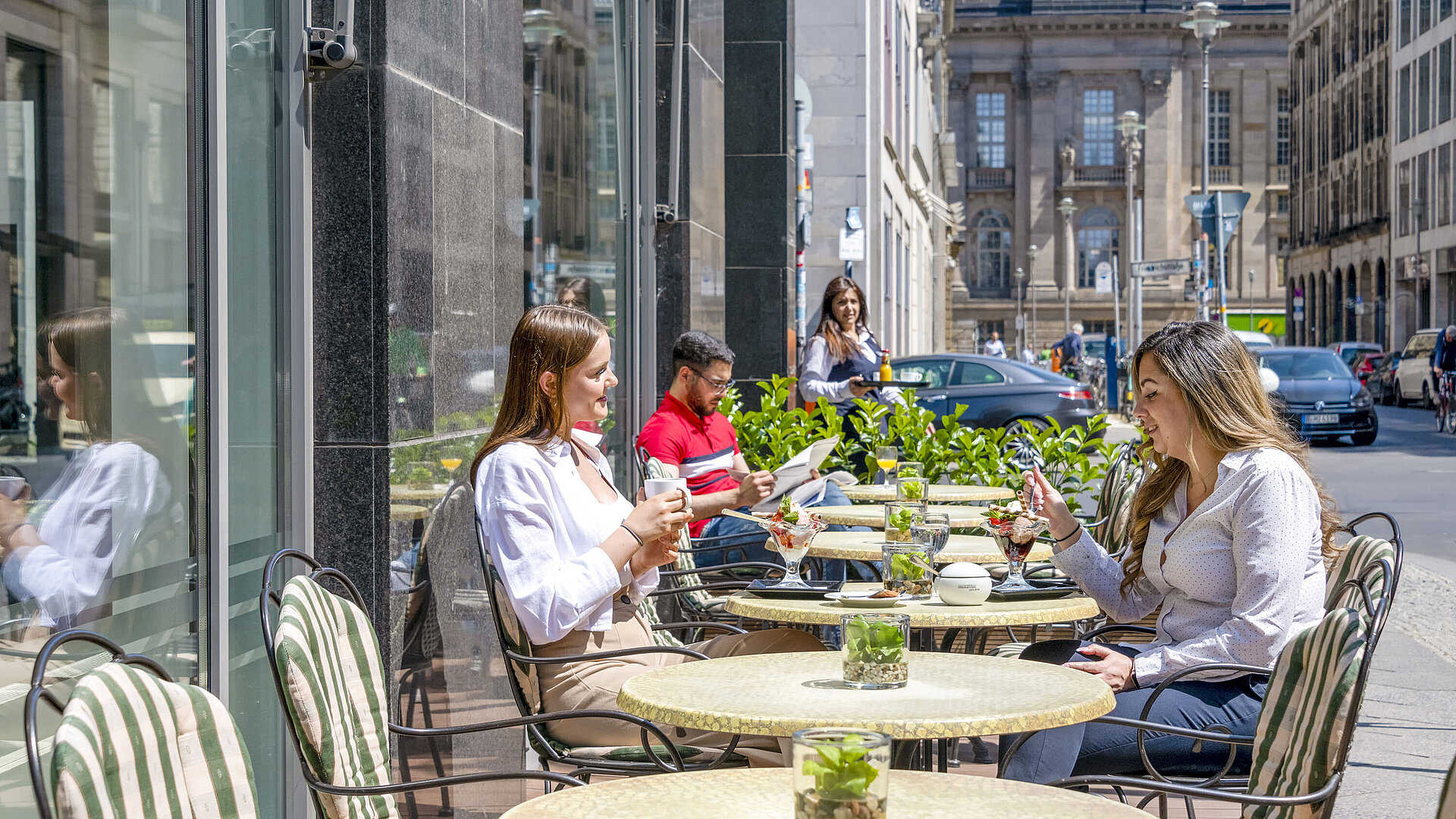 Gäste genießen das sonnige Wetter auf der Terrasse des Maritim proArte Hotels Berlin, ideal zum Entspannen und Verweilen.