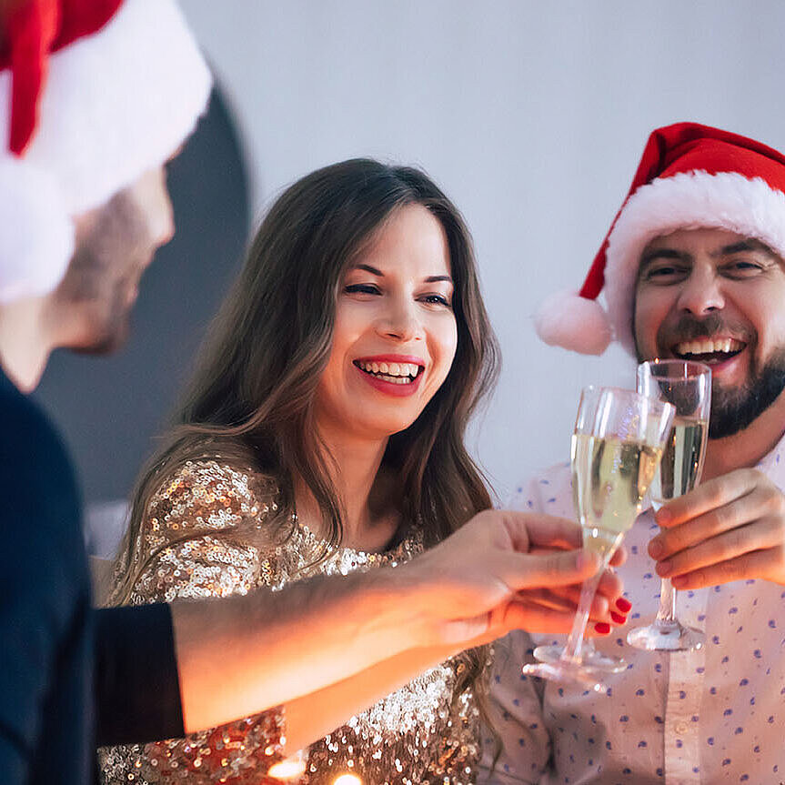 Fröhliche Weihnachtsfeier mit Freunden, Sekt und festlich gedecktem Tisch