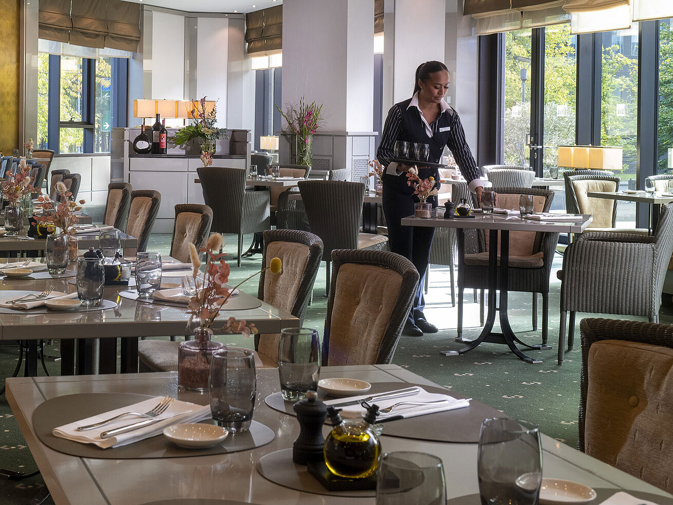 Restaurant Bottacio Stilvoll eingerichtetes Restaurant im Maritim Hotel Düsseldorf mit gedeckten Tischen und einer Servicemitarbeiterin.