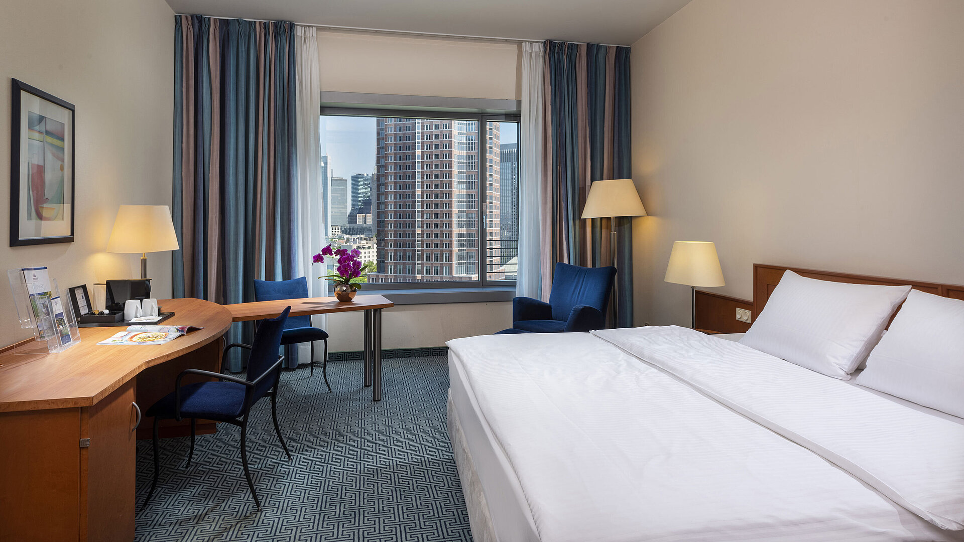 Superior Zimmer im Maritim Hotel Frankfurt mit Doppelbett, Schreibtisch und Blick auf die Frankfurter Skyline.