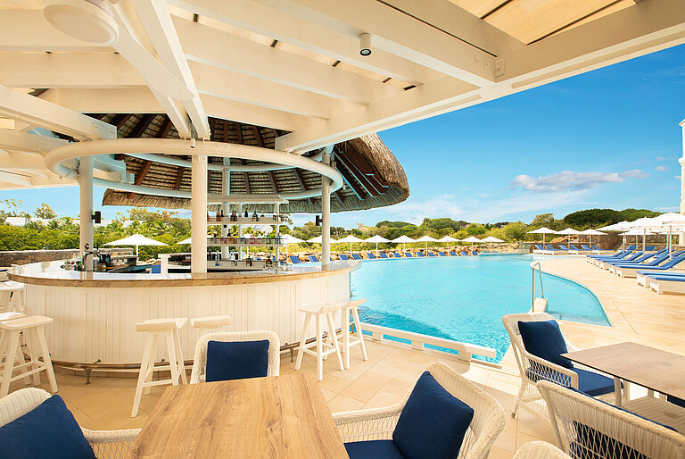 Eine stilvolle Poolbar mit modernen Möbeln und herrlichem Blick auf den Strand und den Poolbereich