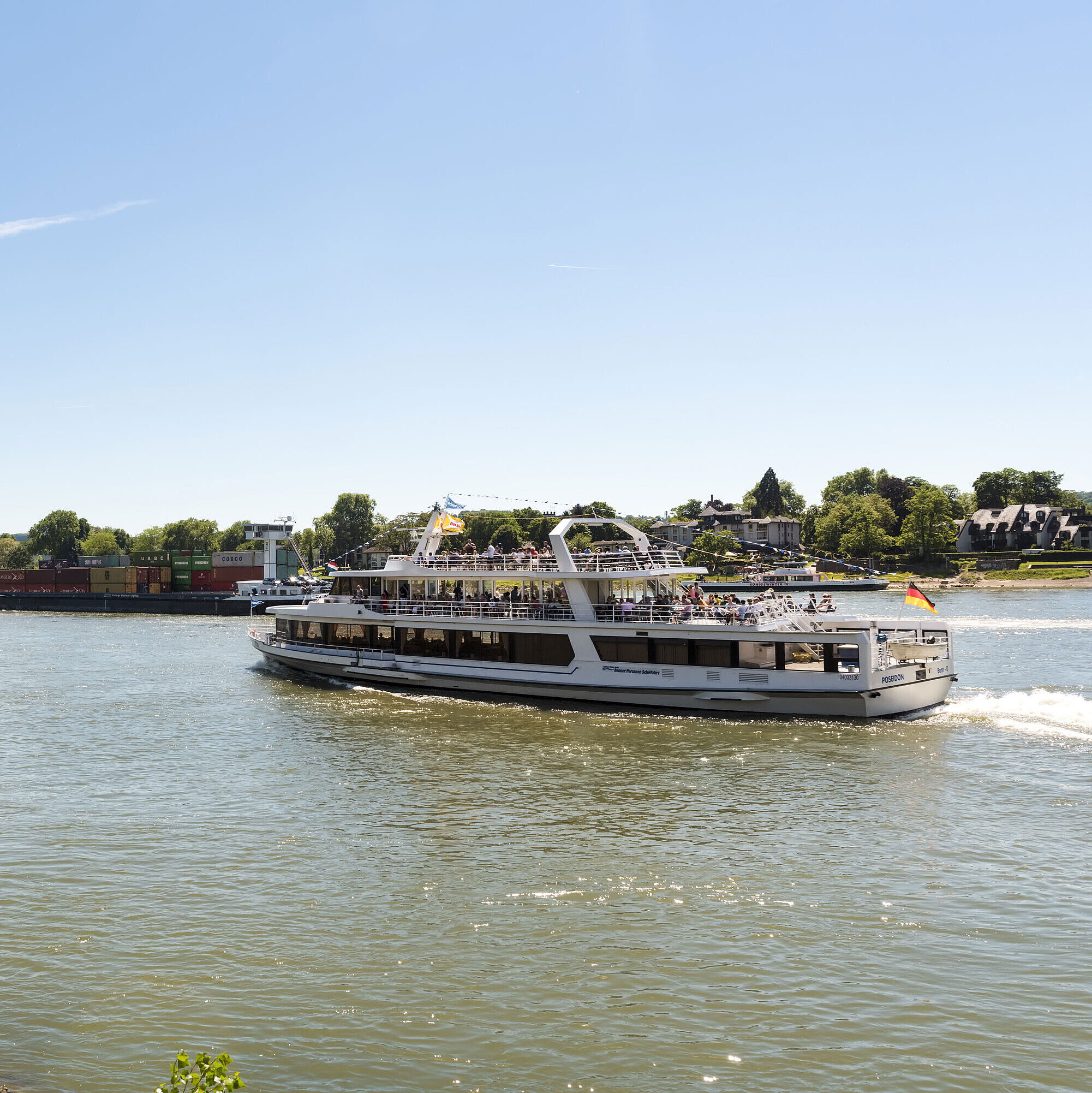 Ein Ausflugsschiff auf dem Rhein nahe Königswinter mit Blick auf die malerische Landschaft.