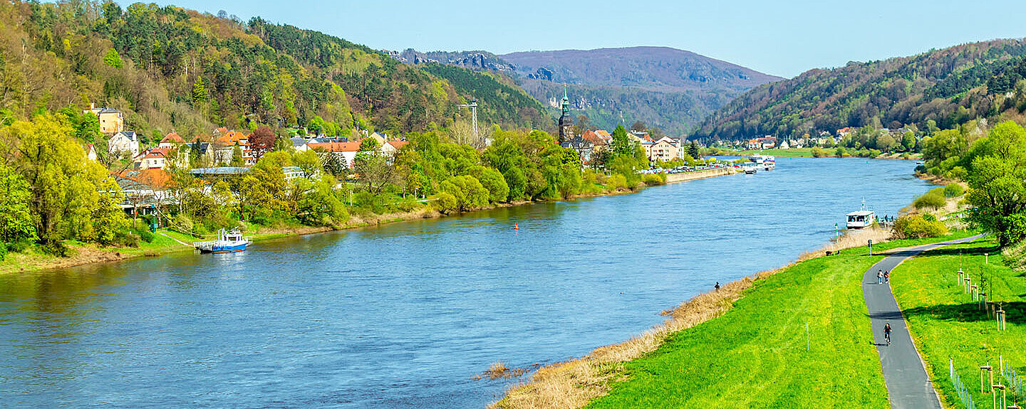 Elbe bei Dresden mit grünen Ufern, sanften Hügeln und weiter Landschaft unter blauem Himmel.