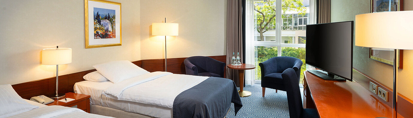 Classic Zweibettzimmer im Maritim Hotel Würzburg mit zwei Einzelbetten, Schreibtisch und Balkon