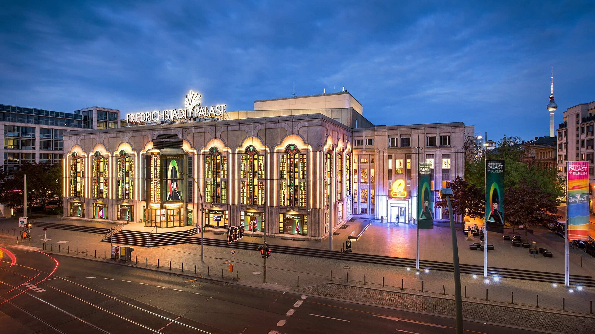 Friedrichstadtpalast Beleuchteter Friedrichstadt-Palast in Berlin bei Abenddämmerung mit Fernsehturm im Hintergrund