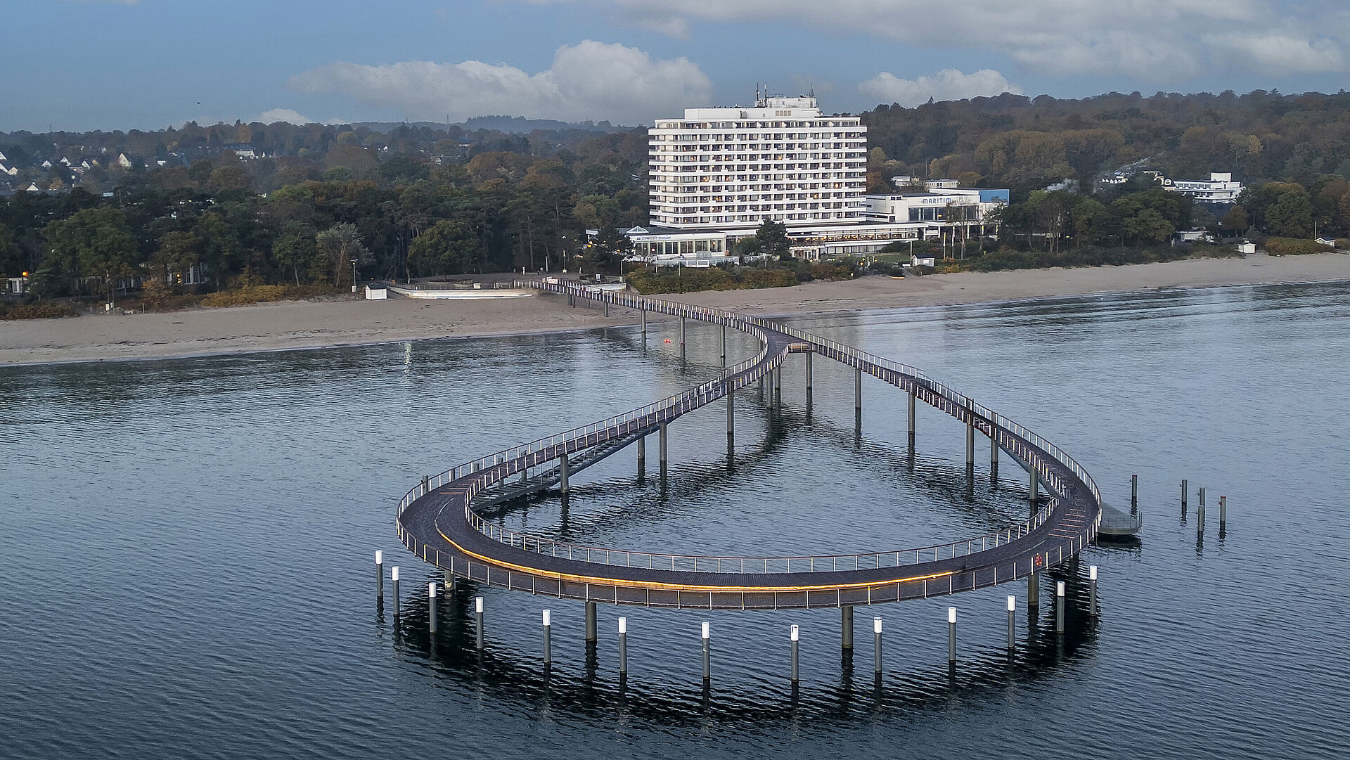 Seebrücke Seebrücke vor dem Maritim Seehotel Timmendorfer Strand mit ruhigem Wasser und blauem Himmel.