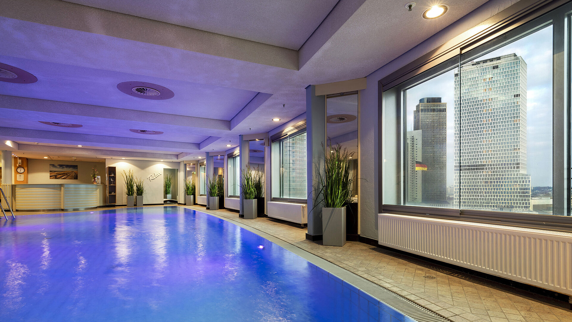 Beleuchteter Indoor-Pool im Maritim Hotel Frankfurt mit entspannter Atmosphäre und Panoramafenstern.