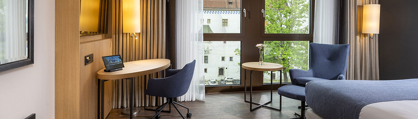 Modern eingerichtetes Hotelzimmer im Maritim Hotel Ingolstadt mit Schreibtisch und Blick auf die Stadt.