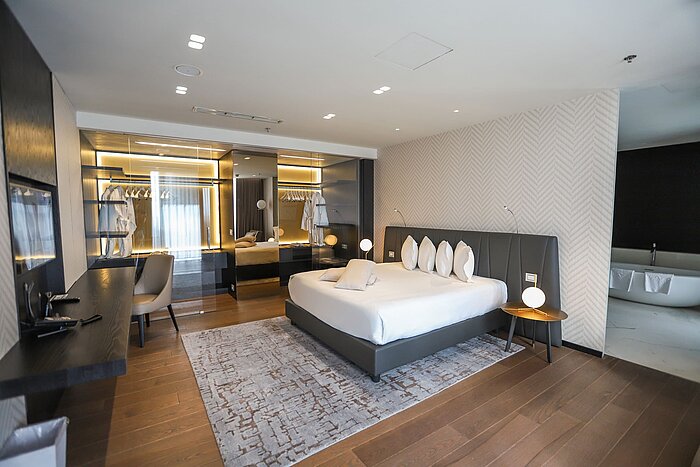 Präsidentensuite Design-Schlafzimmer mit großzügigem Bett, Spiegelwand und Ankleide im Maritim Hotel Plaza Tirana