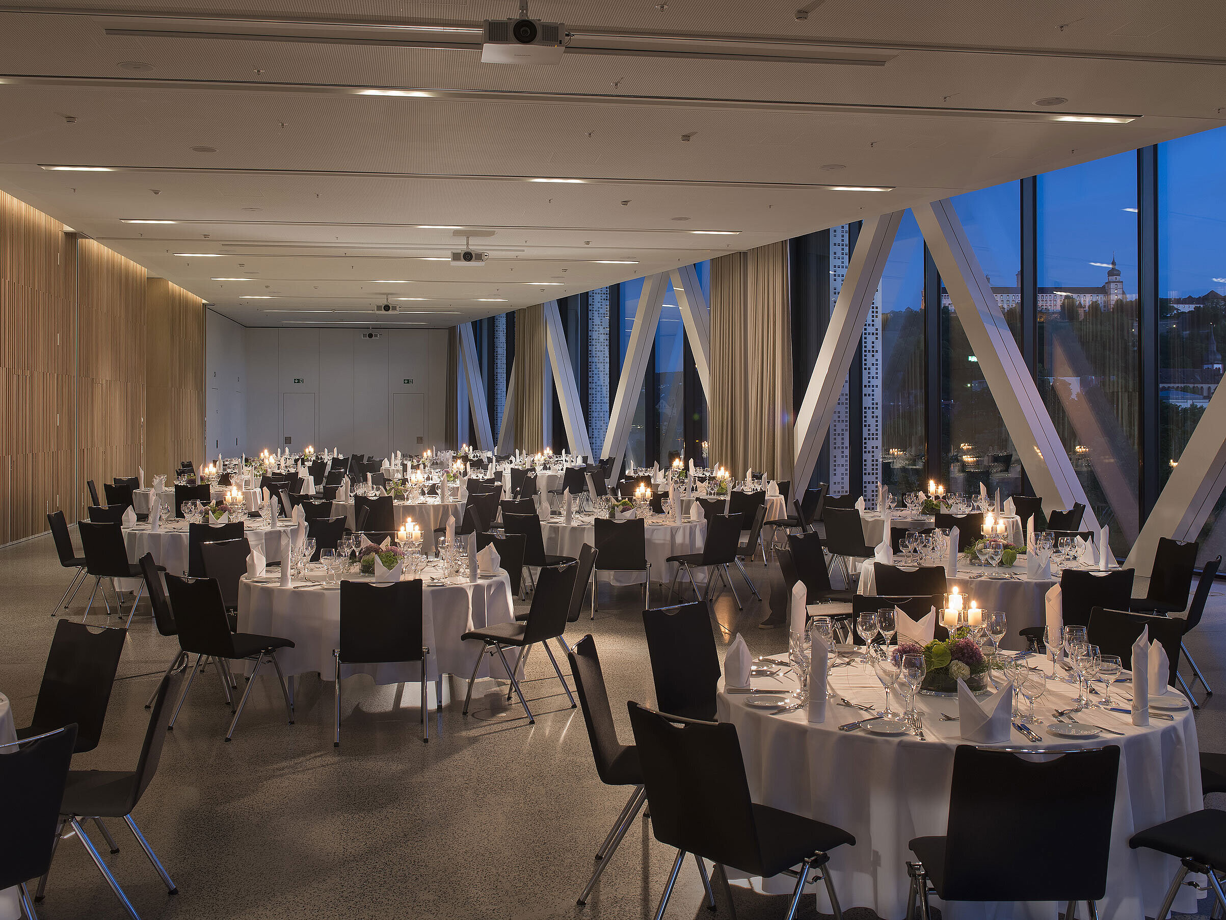 Eleganter Veranstaltungsraum im Maritim Hotel Würzburg mit runden Tischen und Blick auf die Festung