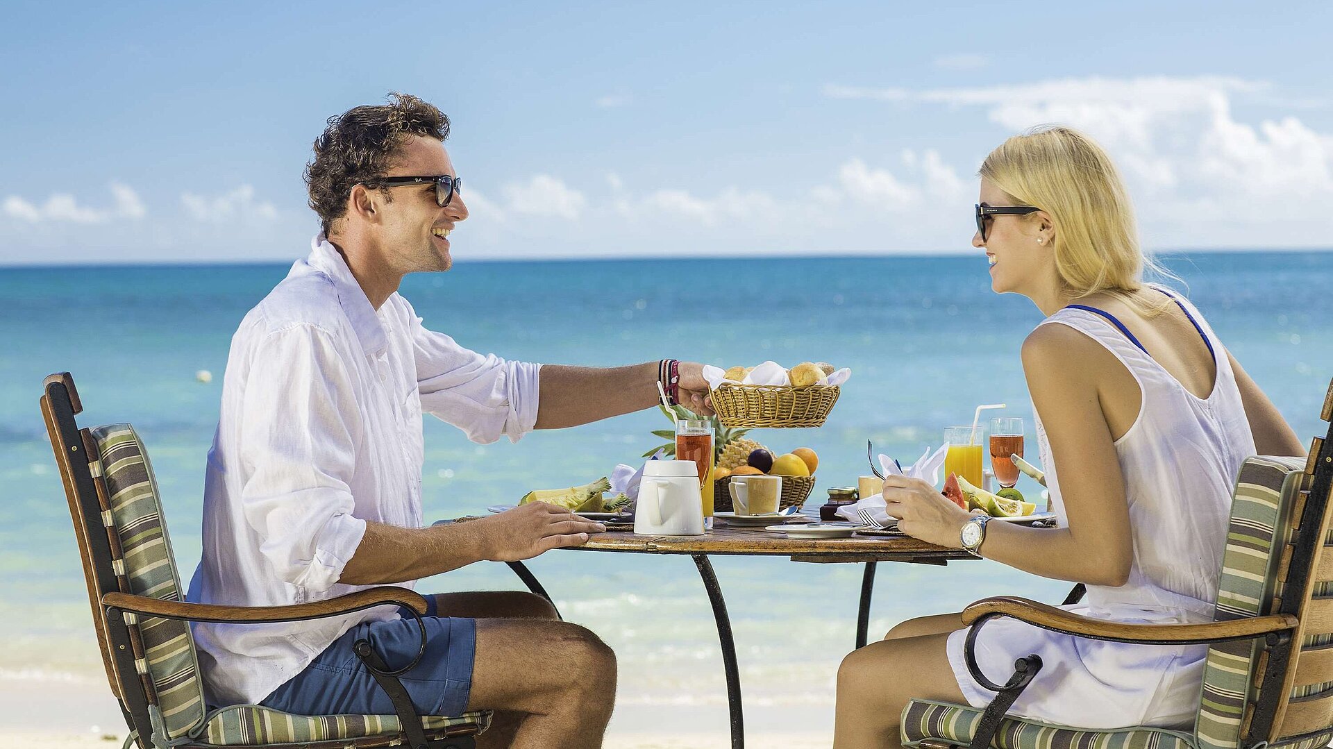 Frühstück am Strand Paar genießt entspanntes Frühstück am Strand mit Meerblick an einem sonnigen Urlaubstag