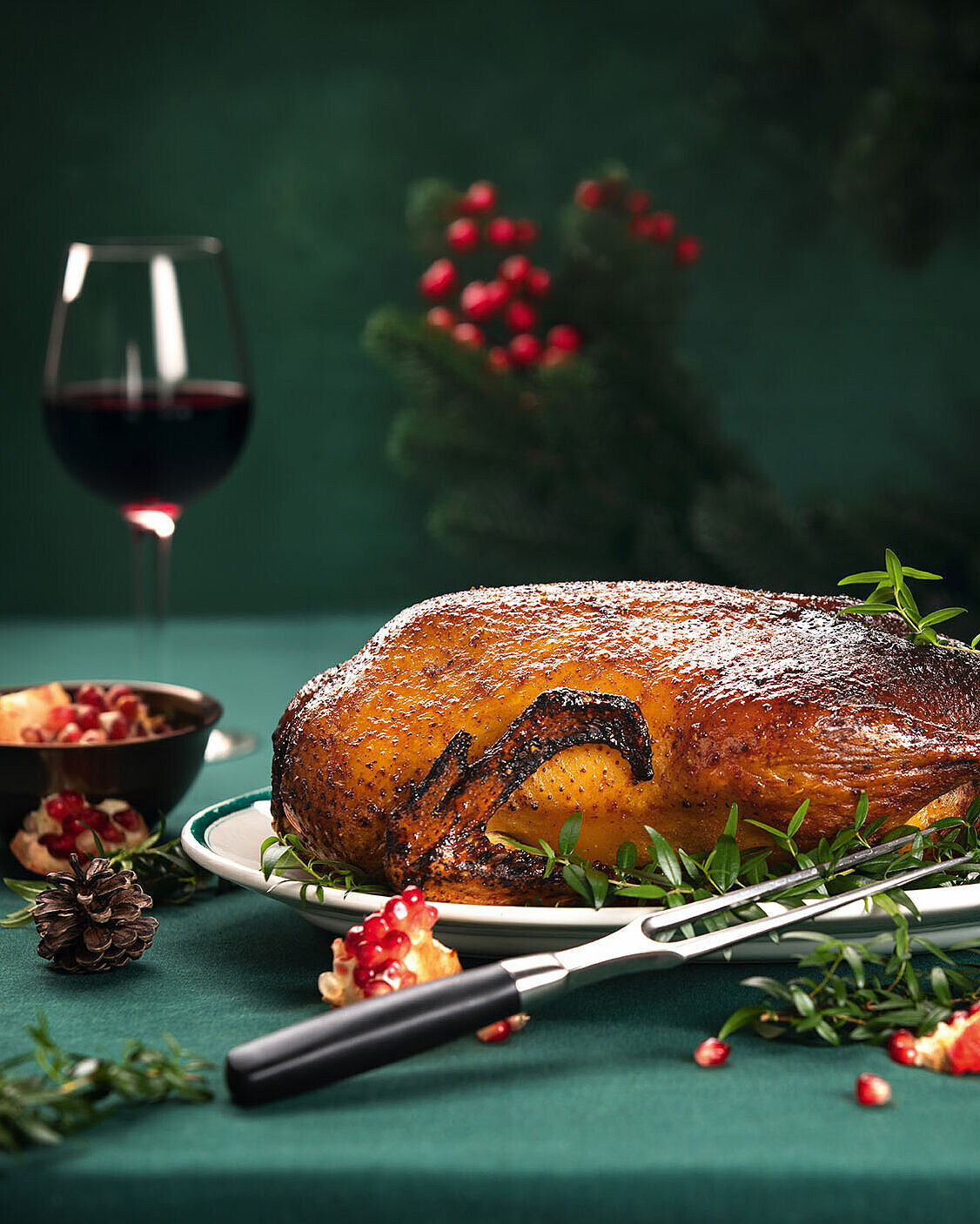 © fortyforks - AdobeStock.com Festlicher Gänsebraten mit Rotwein und weihnachtlicher Tischdekoration
