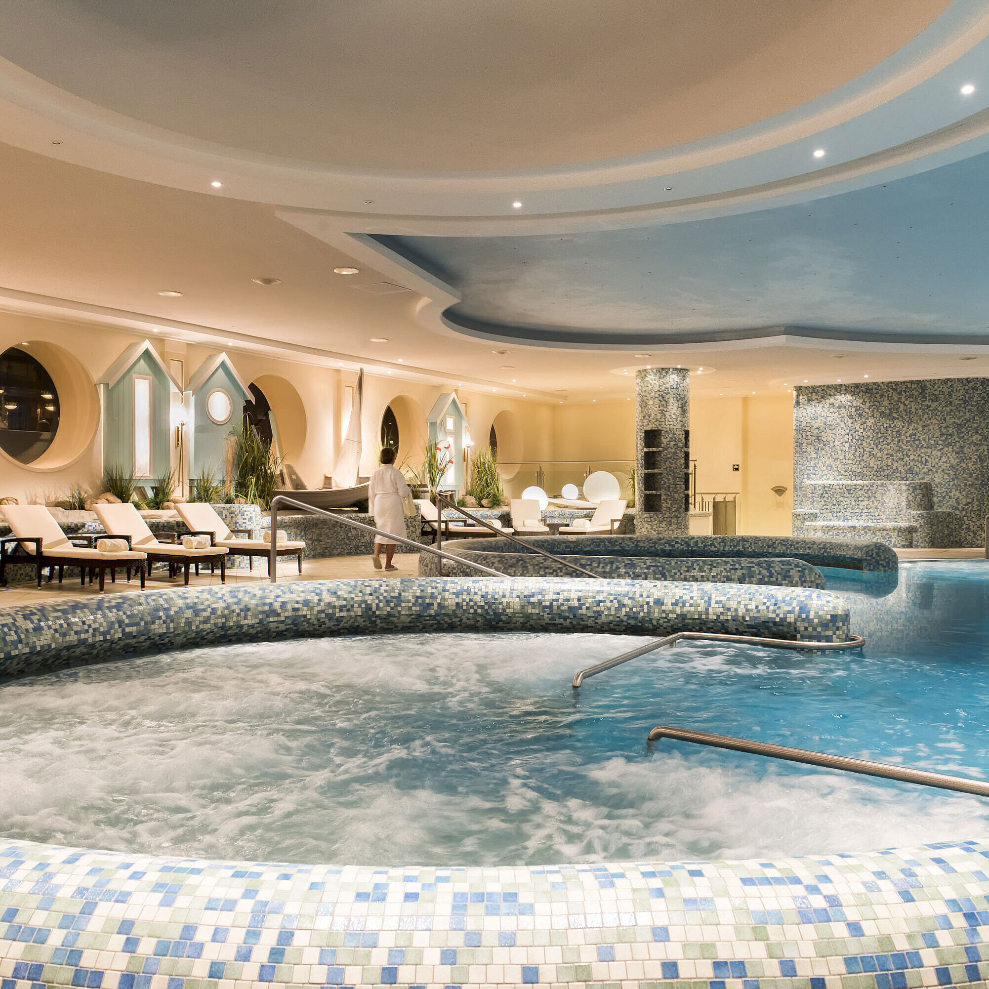 Großzügiger Wellnesspoolbereich mit Whirlpool und Liegestühlen im Maritim Seehotel Timmendorfer Strand.
