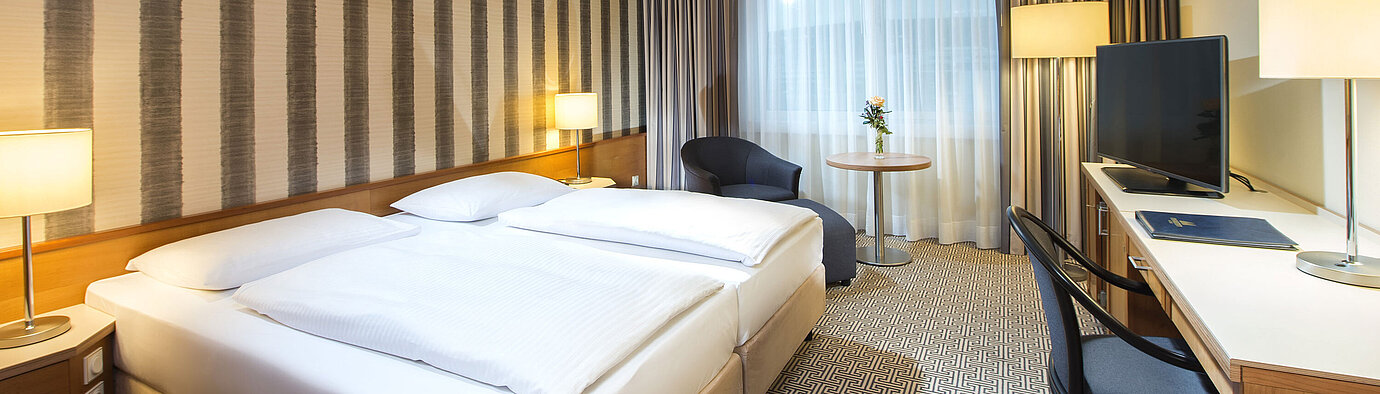 Modern eingerichtetes Doppelzimmer mit Schreibtisch, Fernseher und Tageslicht im Maritim Hotel Stuttgart