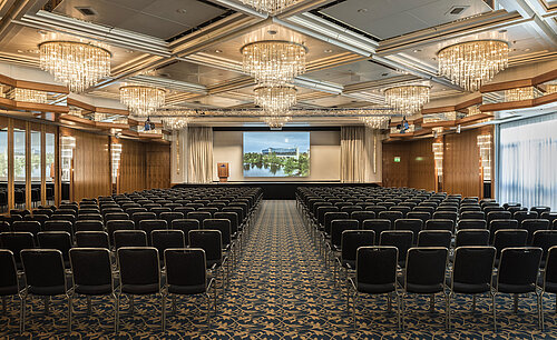 Eleganter Veranstaltungssaal mit Kristalllüstern, Reihenbestuhlung und großer Bühne im Maritim Hotel Hannover.