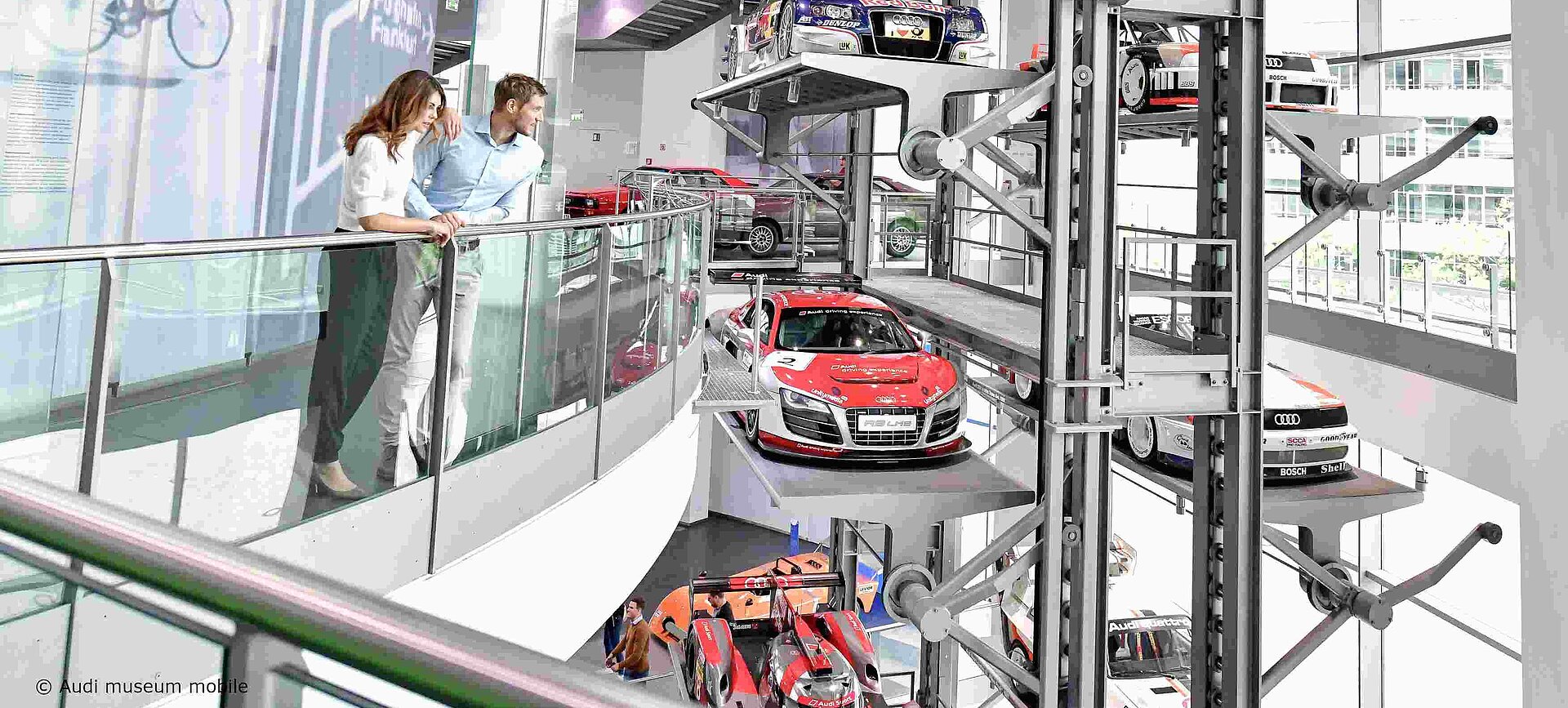 Besucher sehen sich das Audi Museum mobile an, mit Autos auf einem Fahrstuhl