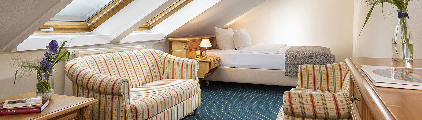 Familiensuite Charmantes Zimmer mit Dachfenstern, Sofa und Sessel im Maritim Hotel Titisee