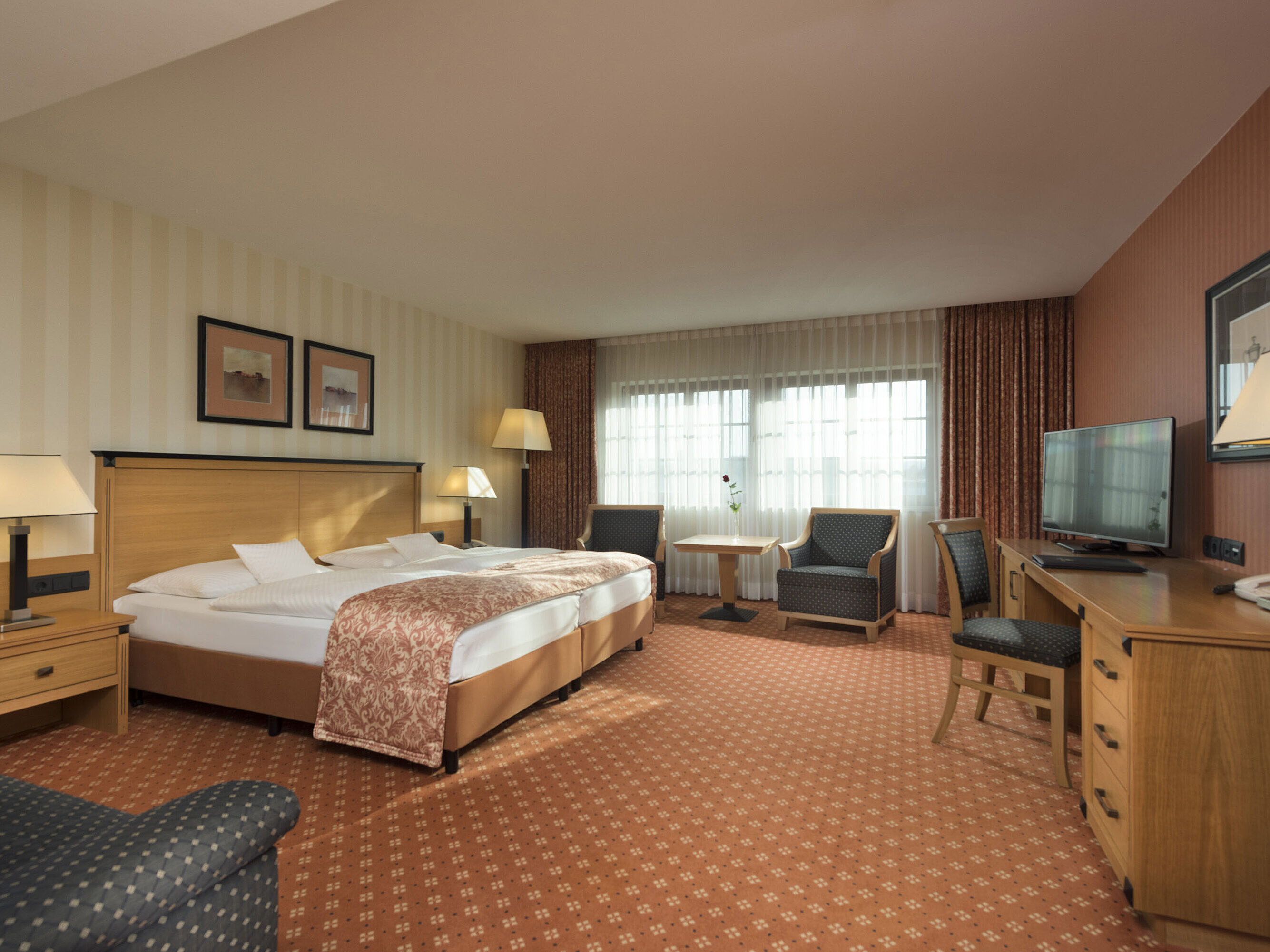 Classic Zimmer im Maritim Hotel Dresden mit Doppelbett, Sitzbereich und klassischem Dekor.