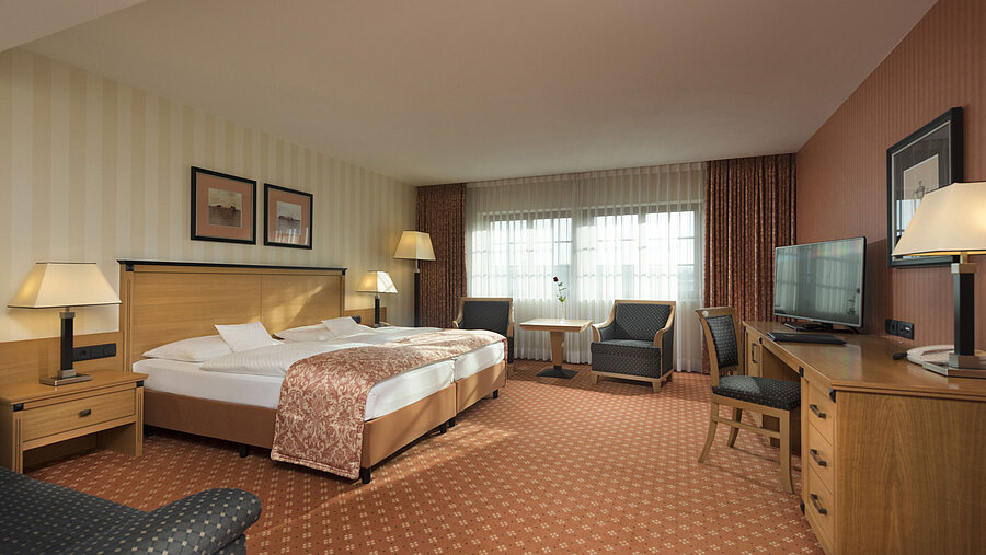 Classic Zimmer im Maritim Hotel Dresden mit Doppelbett, Sitzbereich und klassischem Dekor.