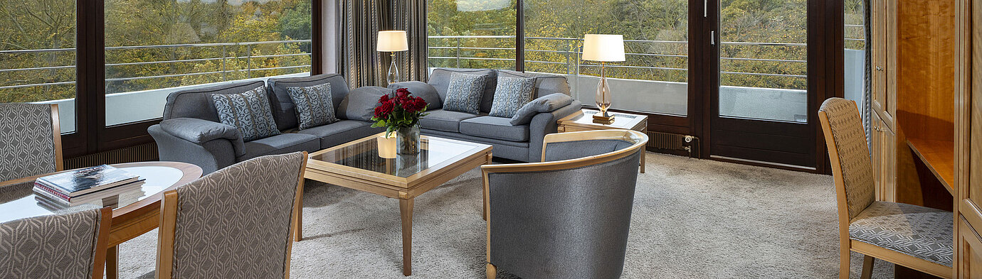 Grand Suite Wohnbereich der Grand Suite im Maritim Hotel Kiel mit großzügigen Fenstern, stilvoller Einrichtung und Blick ins Grüne.