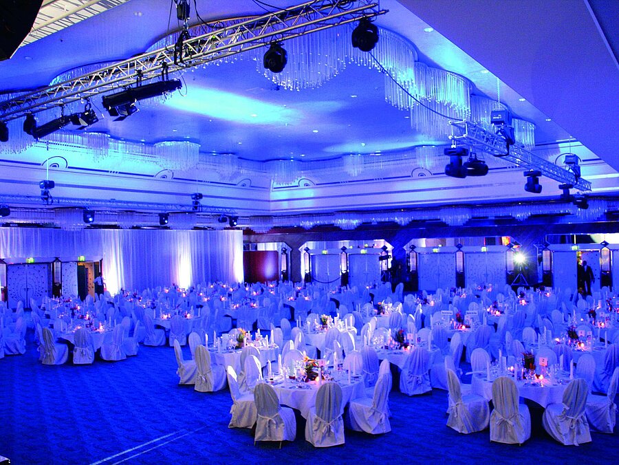 Großer Festsaal mit festlich gedeckten Tischen und blauer Beleuchtung im Maritim Hotel Hannover.