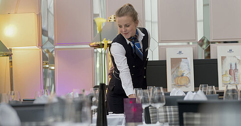 Servicekraft deckt stilvoll den Tisch im Restaurant des Maritim Hotel München