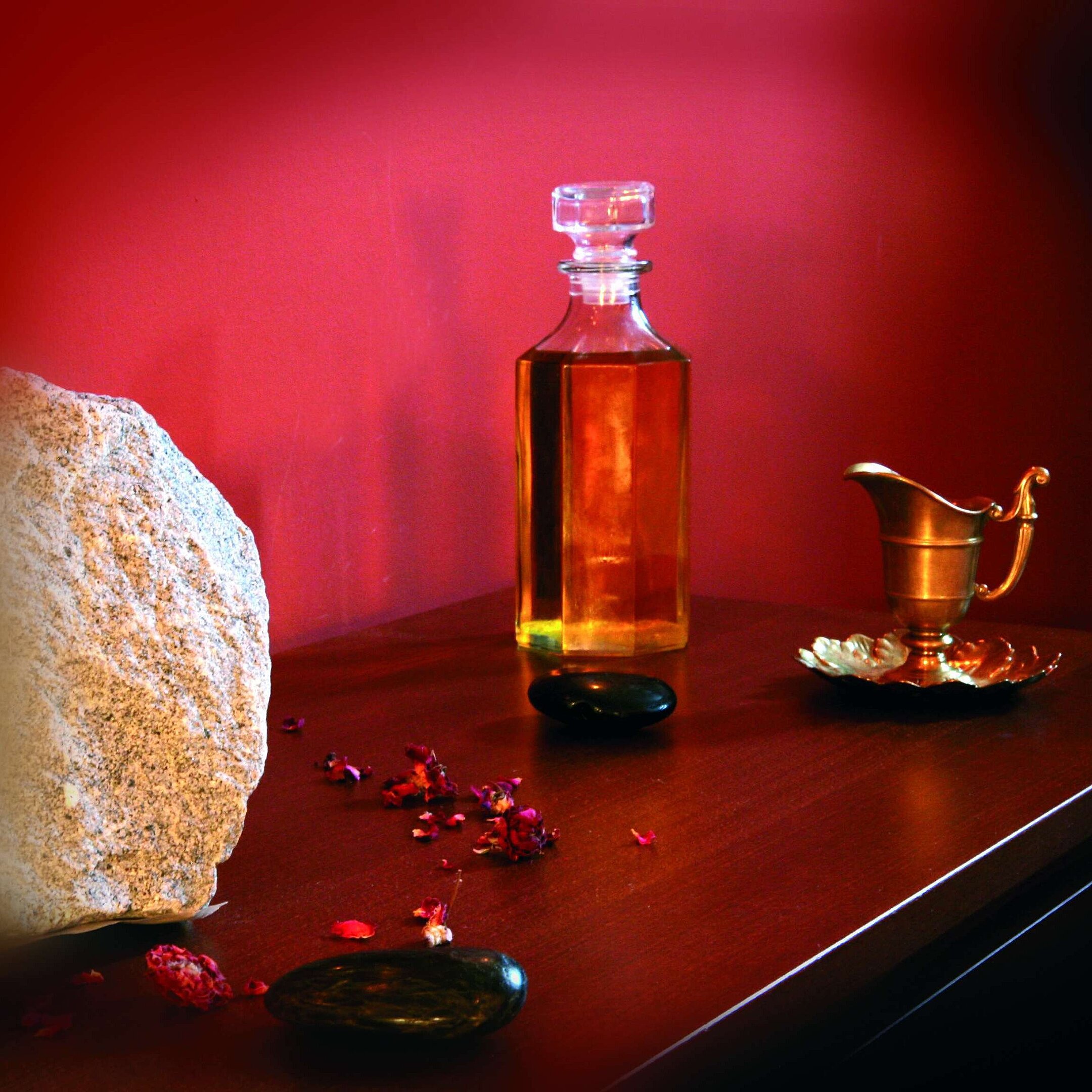 Stimmungsvolle Nahaufnahme mit Flasche Massageöl, Stein und Kupferdeko im Maritim Hotel Bad Wildungen
