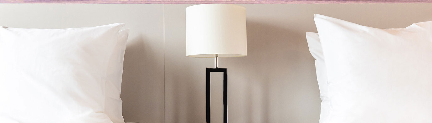 Nachttisch mit Lampe zwischen zwei Betten im Maritim Hotel Amsterdam