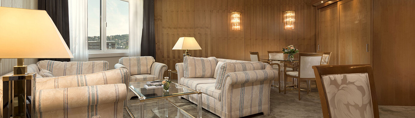 Geräumiges Wohnzimmer mit großem Fenster und Sitzgruppe im Maritim Hotel Stuttgart