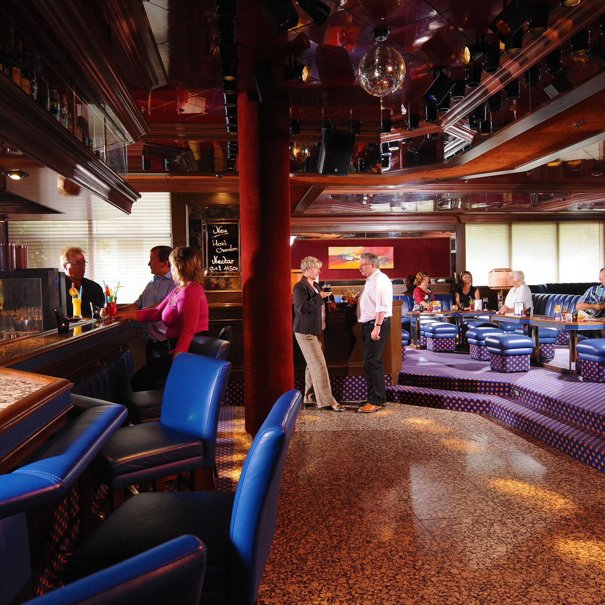 Gäste genießen Drinks in der stilvollen Bar des Maritim Hotel Würzburg mit gemütlicher Atmosphäre