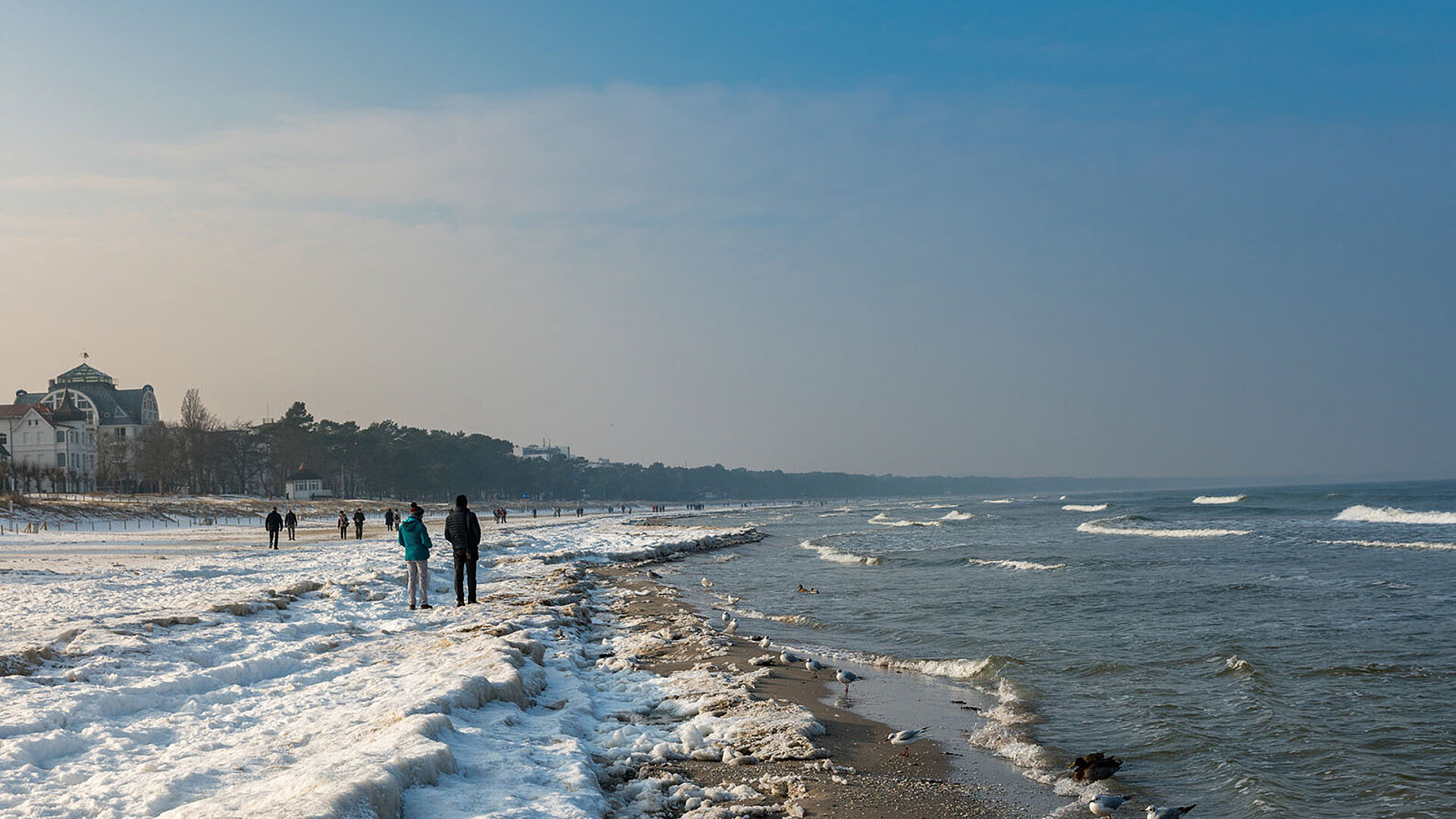 © spuno - AdobeStock.com Ostseeküste mit Wellen, Strand und Blick auf die Küstenlandschaft bei blauem Himmel