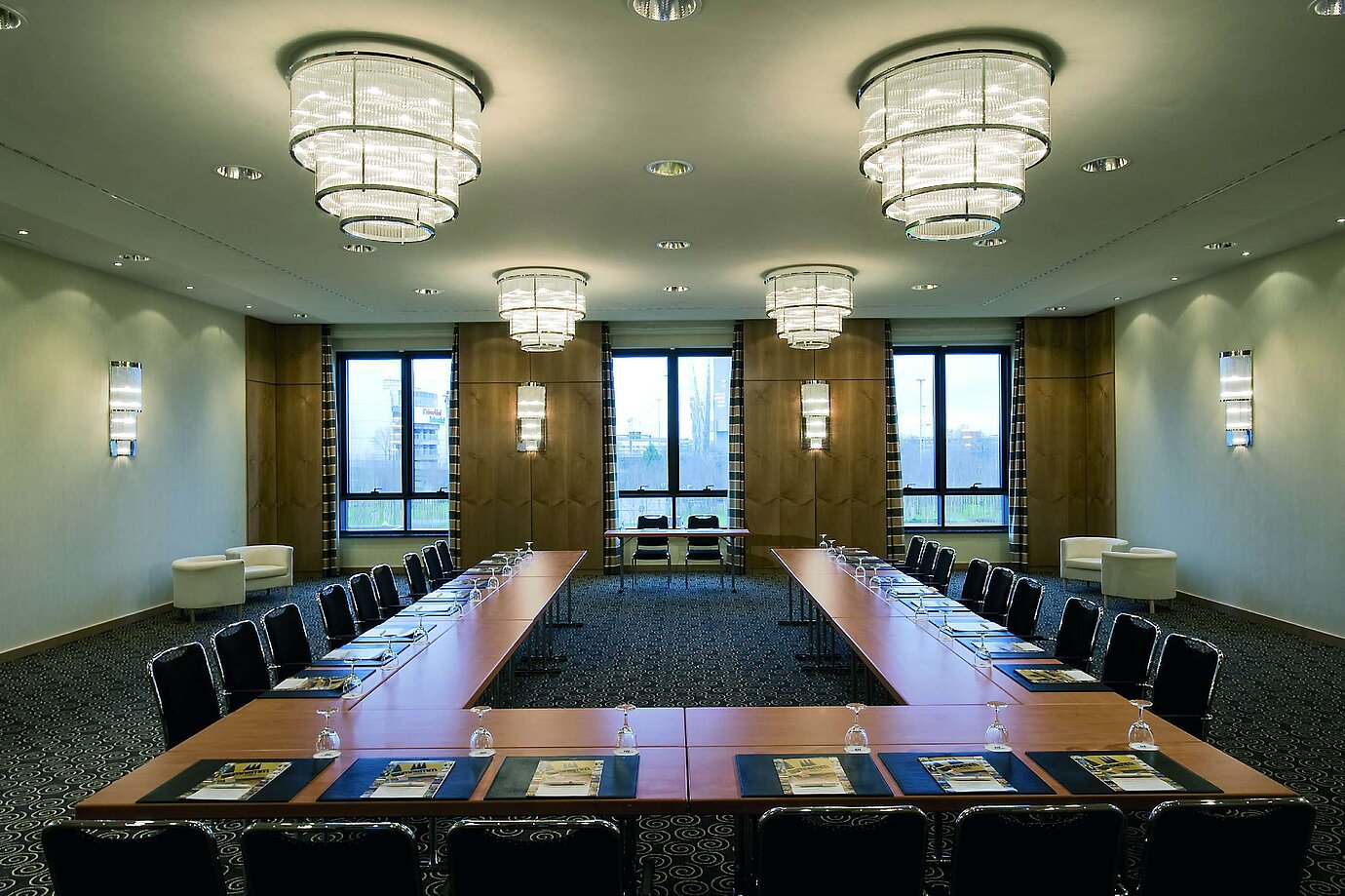 Moderner Konferenzraum im Maritim Hotel Düsseldorf mit U-förmiger Bestuhlung, großen Fenstern und eleganter Beleuchtung.