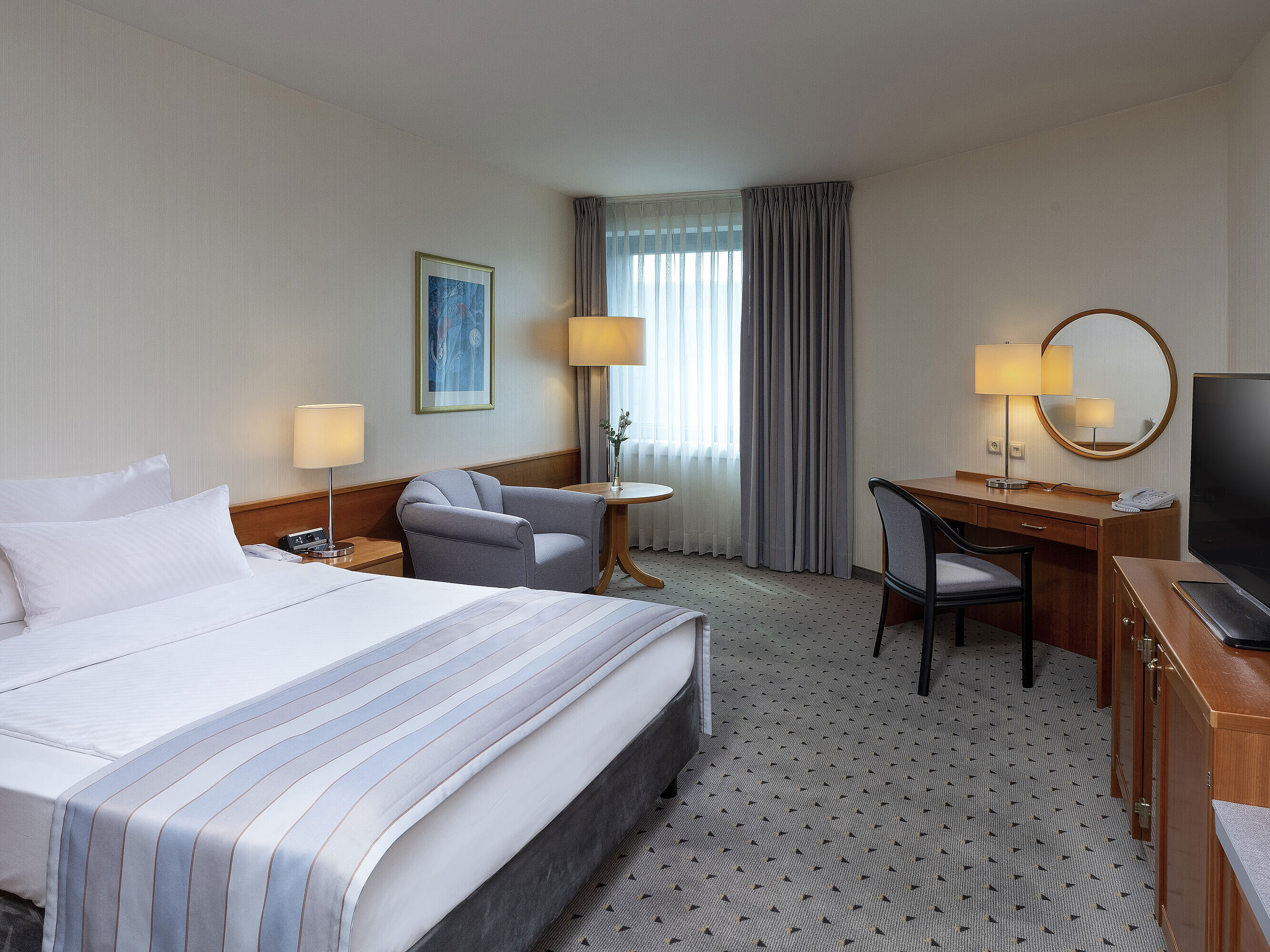 Gemütliches Classic Zimmer mit großem Bett, Schreibtisch, TV und eleganter Einrichtung im Maritim Hotel Hannover.