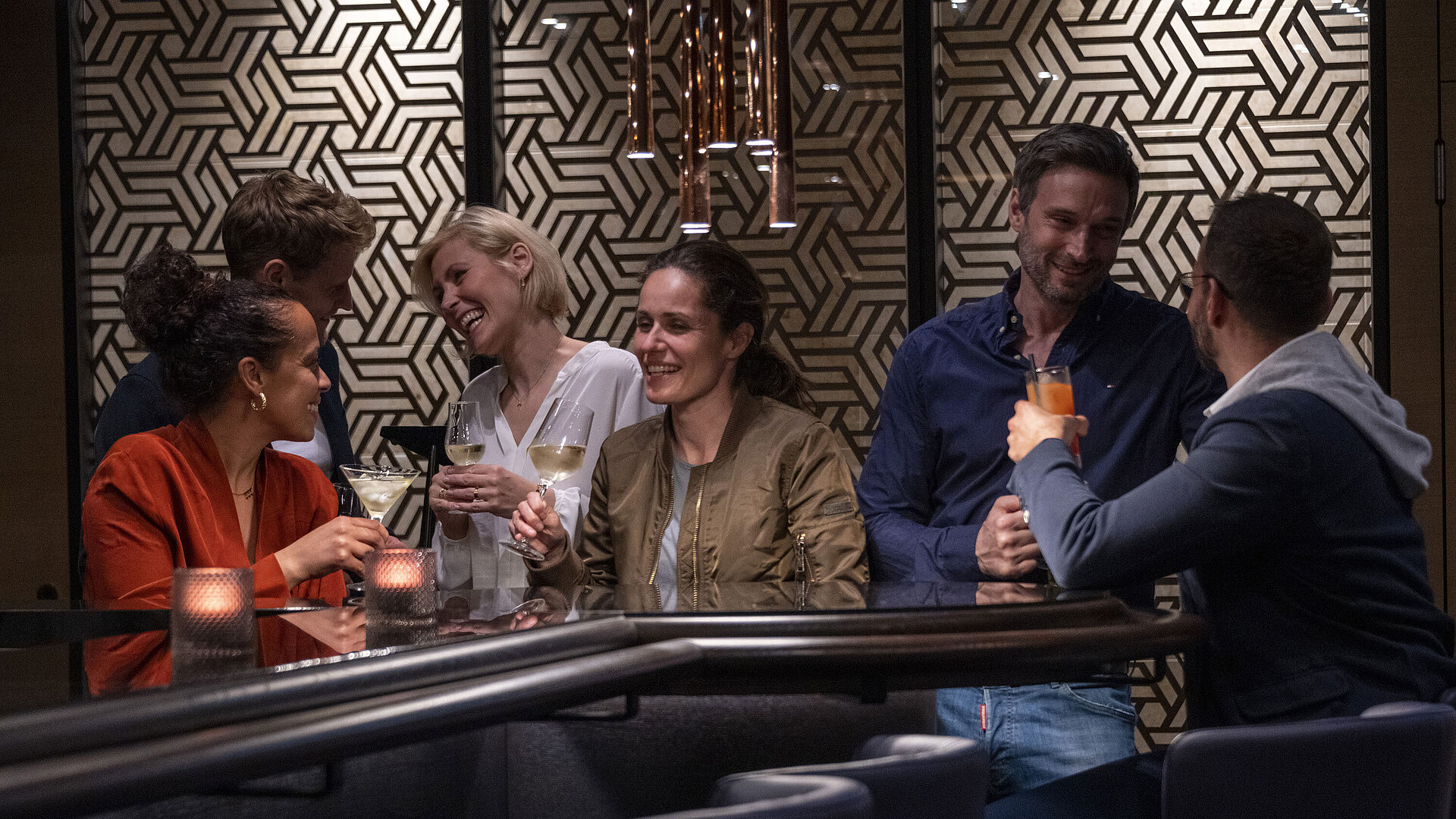 Gäste genießen Drinks und gesellige Gespräche in der stilvollen Bar des Maritim Hotel Ingolstadt.