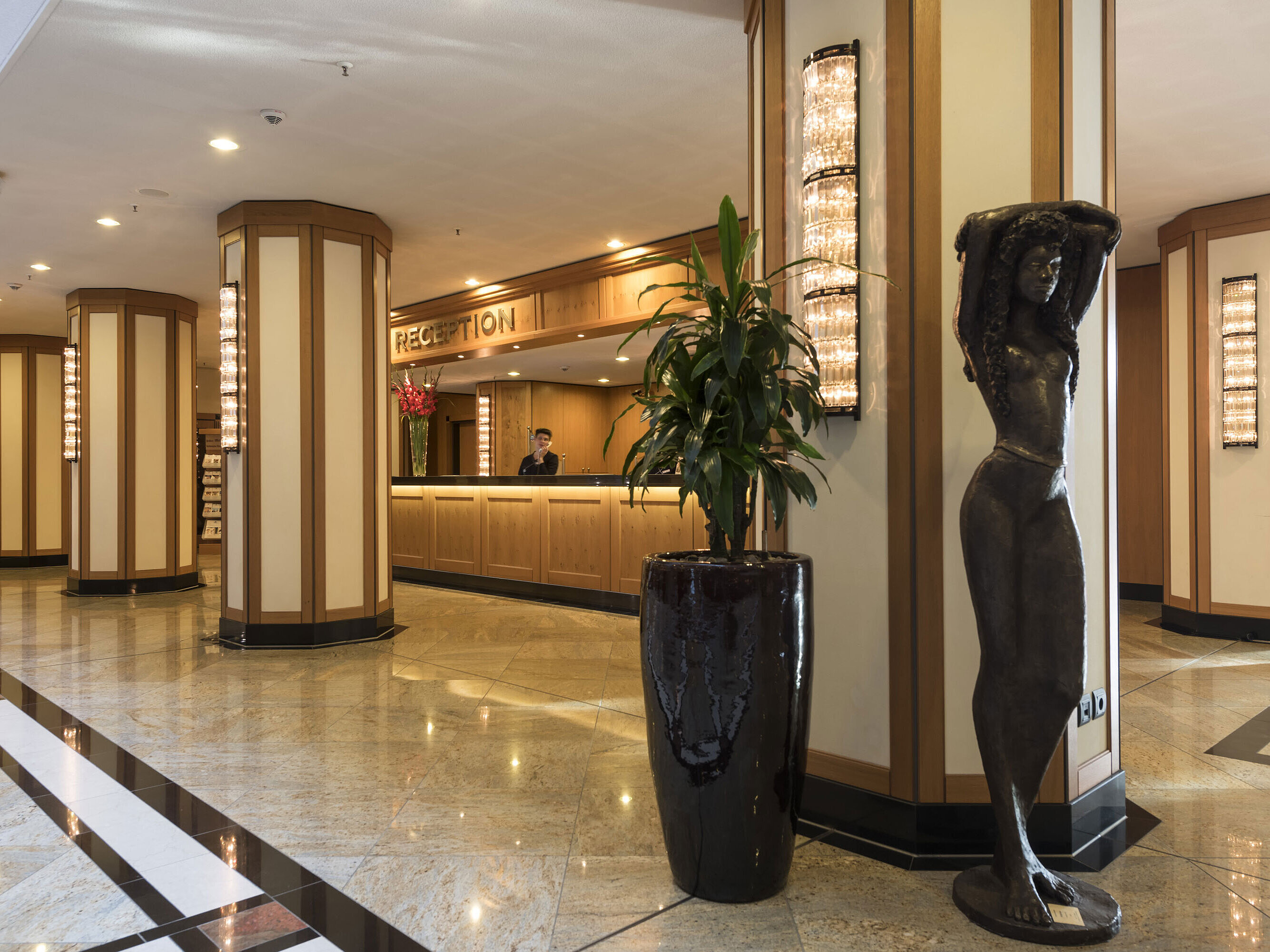 Eleganter Empfangsbereich des Maritim Hotel Dresden mit Skulptur und moderner Beleuchtung.