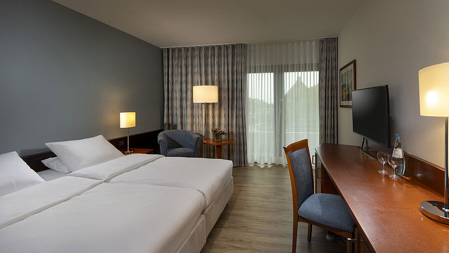 Modern eingerichtetes Allergiker-Zimmer im Maritim Hotel Darmstadt mit Holzfußboden, Doppelbett,Schreibtisch und Balkonzugang
