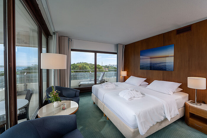 SuperiorPlus Zimmer Seeseite SuperiorPlus Zimmer Seeseite mit Doppelbett, Sitzecke und Blick auf die Ostsee und ins Grüne