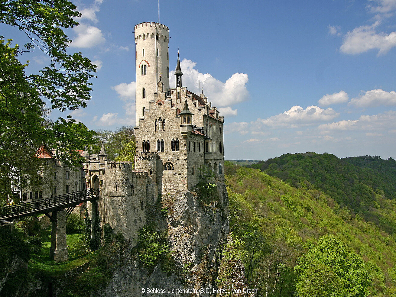 Schloss Lichtenstein auf einem Felsen über dem Echaztal, umgeben von Wäldern der Schwäbischen Alb.
