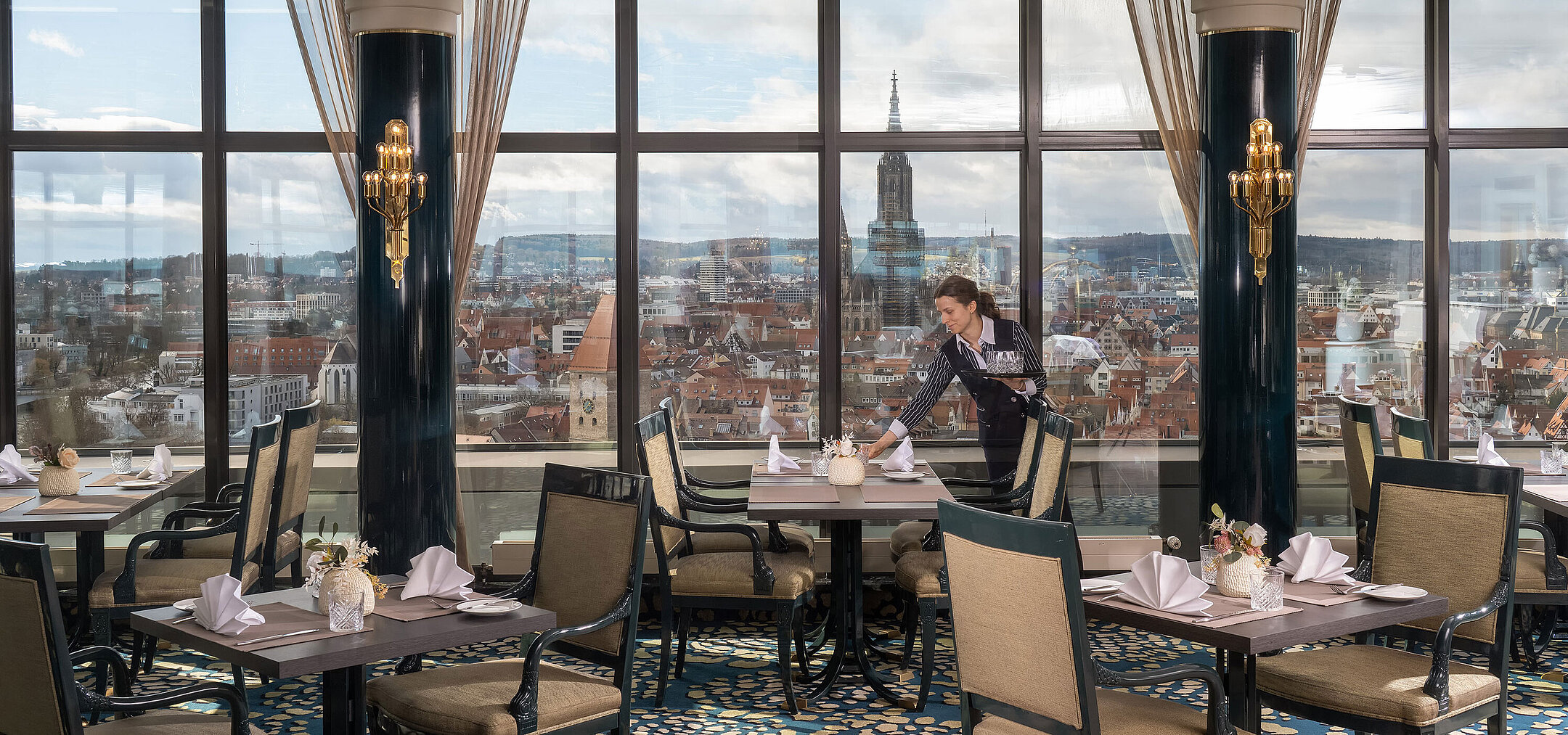 Restaurant im Maritim Hotel Ulm mit gedeckten Tischen, großen Fenstern und Blick über Ulm mit dem Ulmer Münster