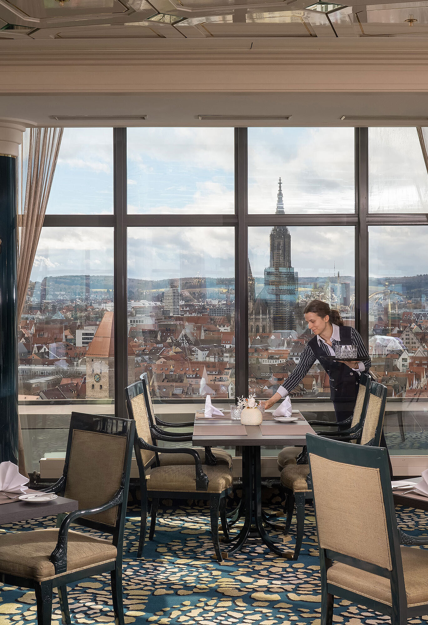 Restaurant im Maritim Hotel Ulm mit gedeckten Tischen, großen Fenstern und Blick über Ulm mit dem Ulmer Münster