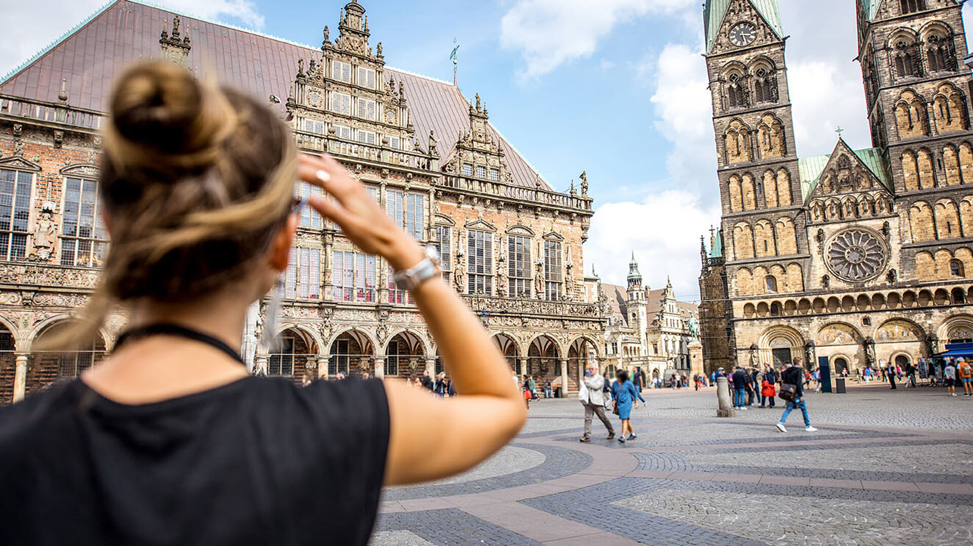 © rh2010 - AdobeStock.com Touristin auf dem Bremer Marktplatz mit Blick auf Rathaus und Bremer Dom in der Altstadt