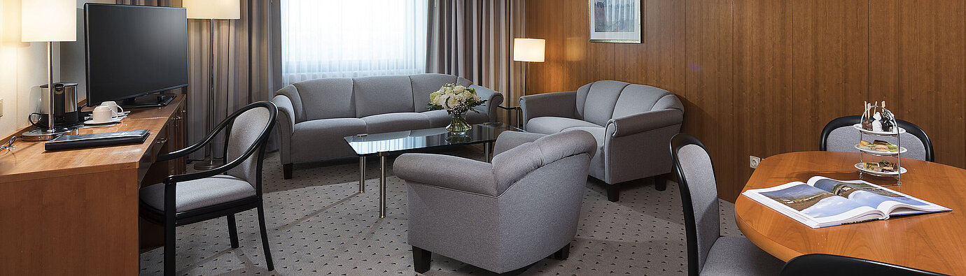 Junior Suite  Junior Suite mit elegantem Wohnbereich, Sofa, Sesseln, Schreibtisch und TV im Maritim Hotel Hannover.