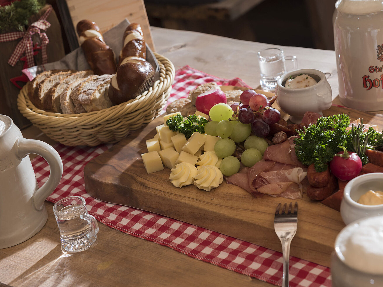 Vesperplatte *Rustikale Brotzeit mit Käse, Wurst, Trauben, Brezen und Bierkrug in der ElbAlm