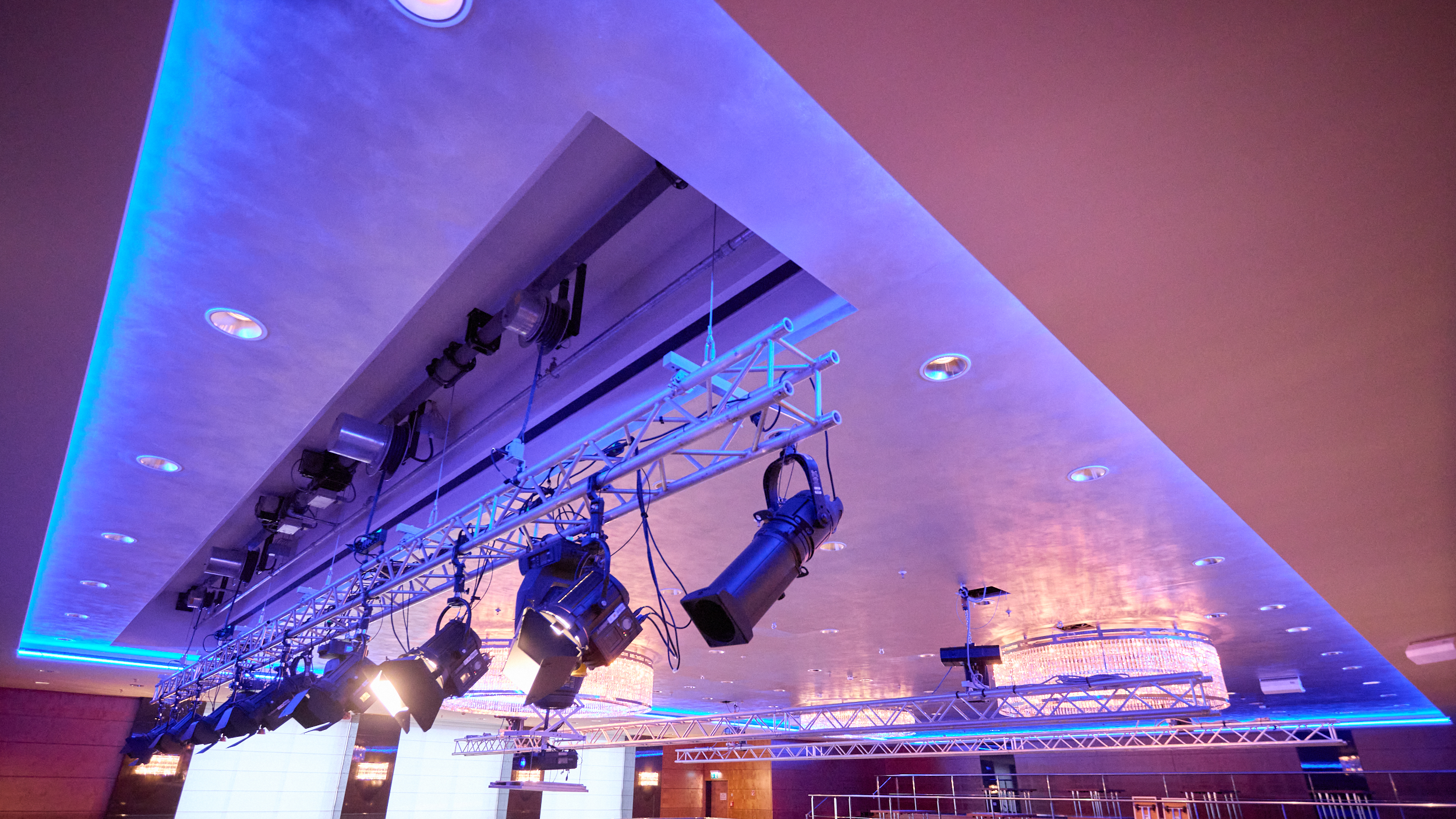 Bühnen- und Lichttechnik im Ballsaal Deckenmontierte Licht- und Bühnentechnik in einem modern beleuchteten Veranstaltungsraum.